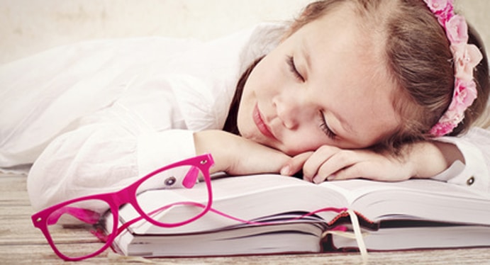 Little girl sleeping on the books